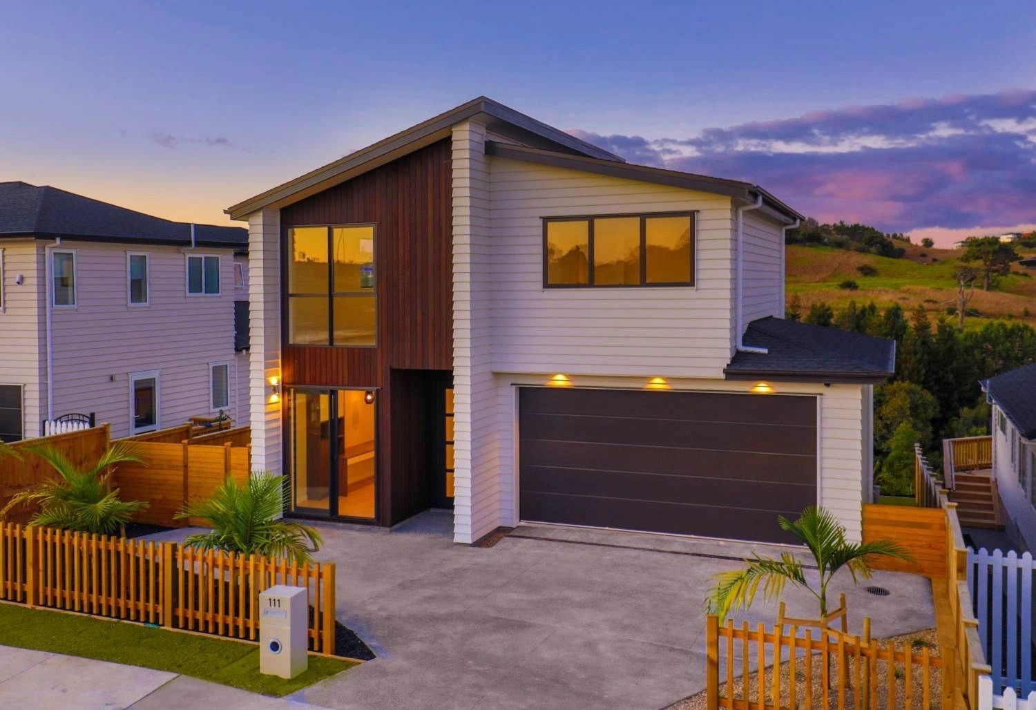 A completed Concord home at dusk with warm interior lighting