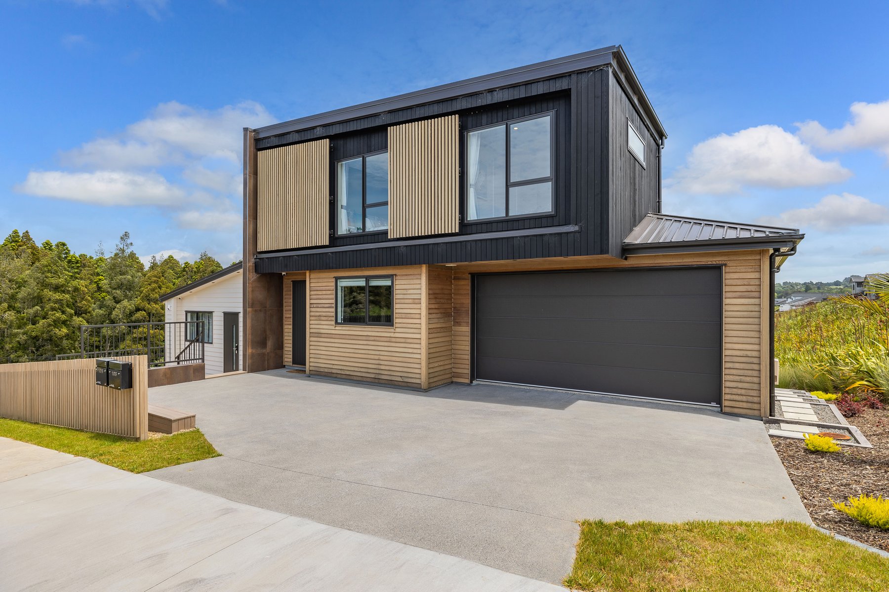 Concord Homes show home exterior in Milldale — timber and dark cladding with double garage