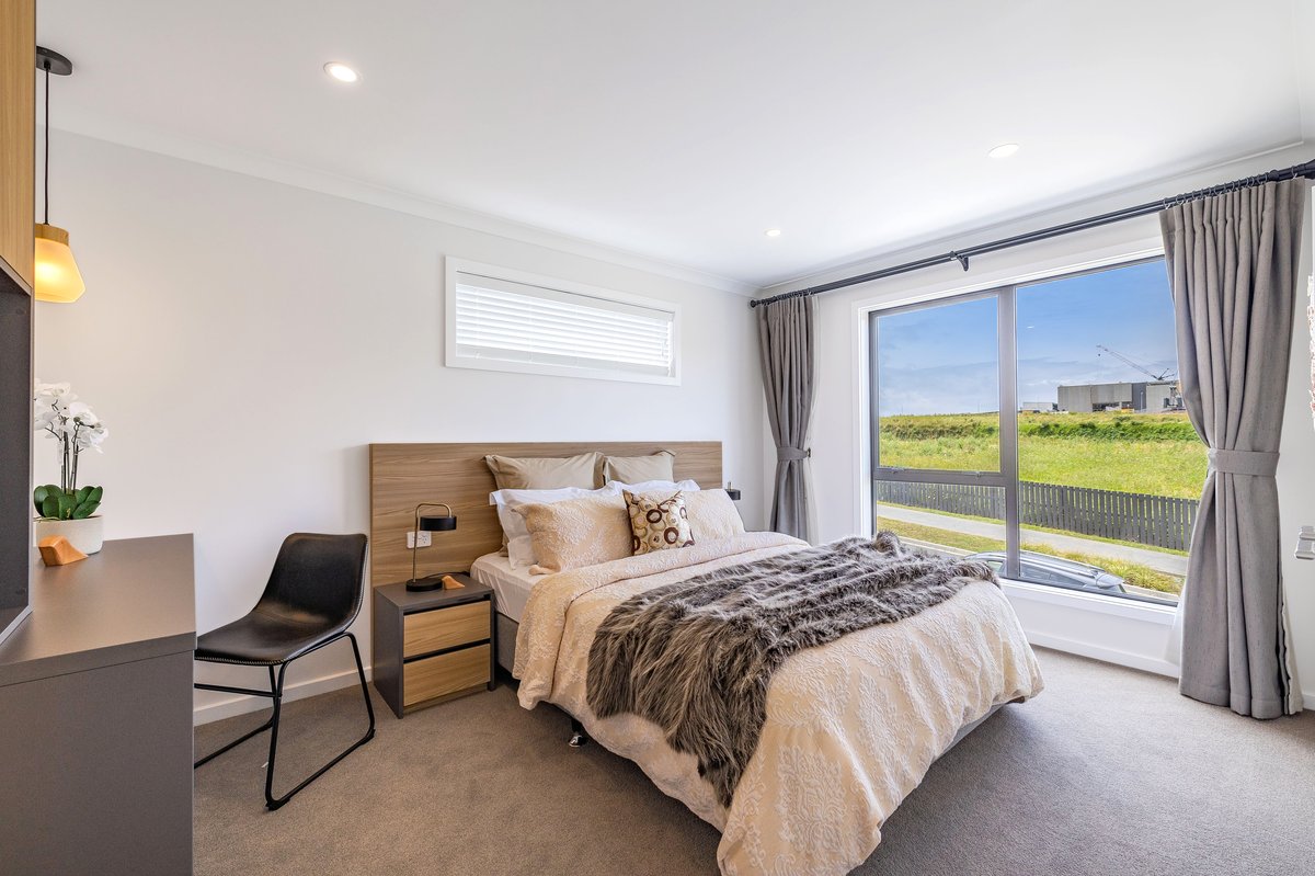 Master bedroom with timber headboard and outdoor views
